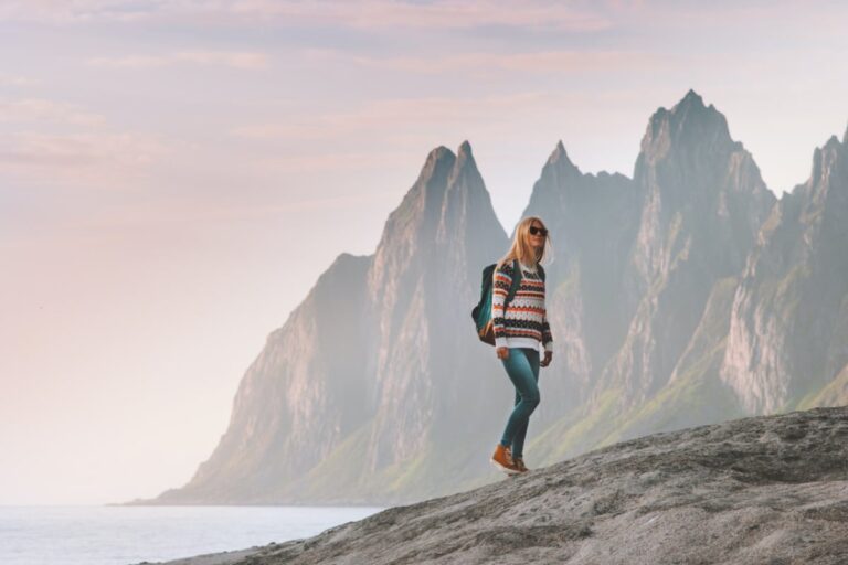Tourist woman traveling in Norway active lifestyle vacations outdoor Okshornan peaks landscape Senja island
